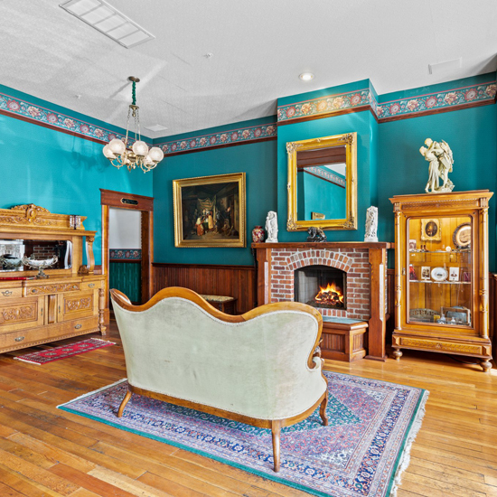 victorian era sofa in front of brick fireplace