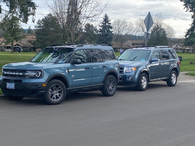 two SUVs parked near a park