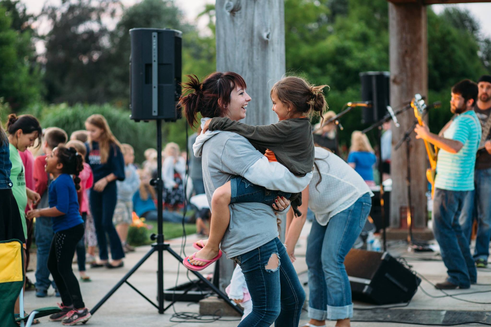 mother and daughter dancing at an outdoor concert