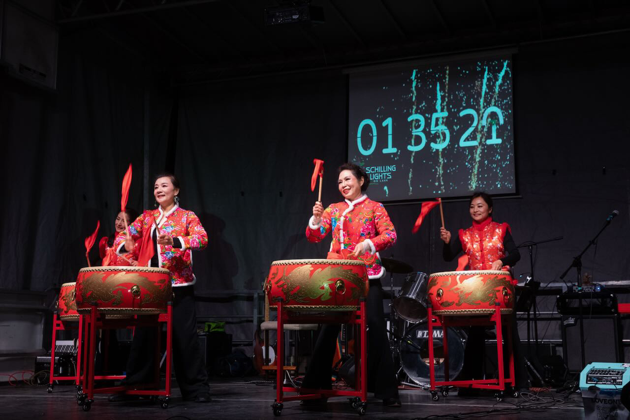 four people play traditional Chinese drums on stage