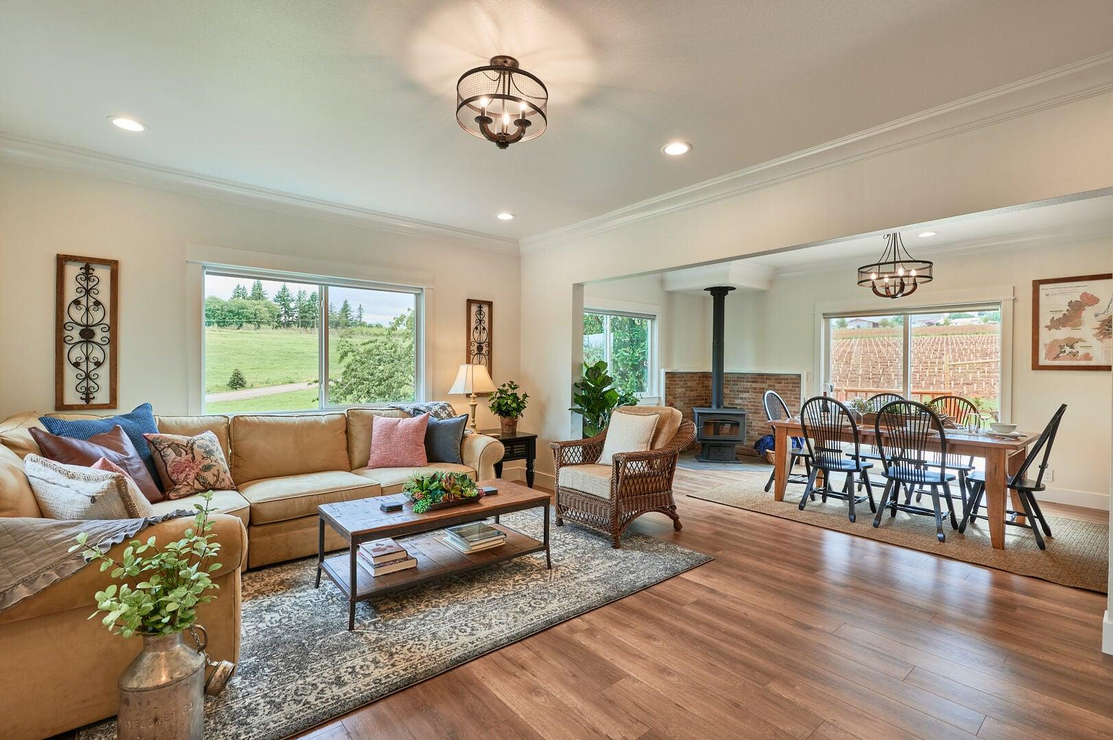 Open-concept living and dining area with a sectional sofa, coffee table and large patterned area rug.ug.