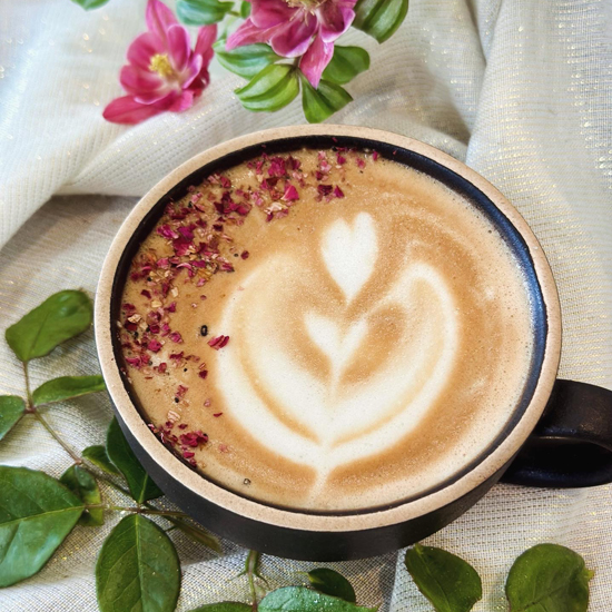 espresso beverage with latte art and sprinkles in mug