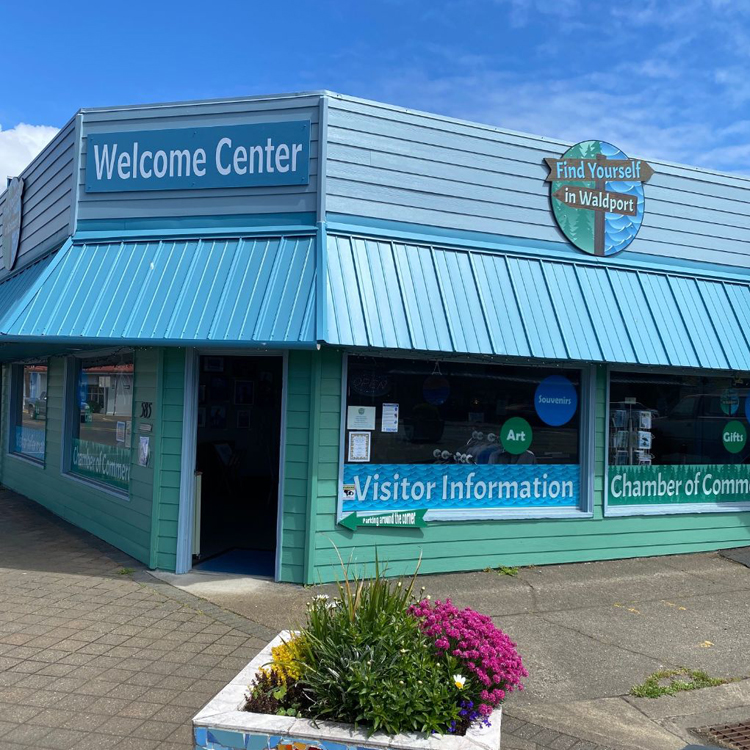 exterior of one story building with Welcome Center sign over door