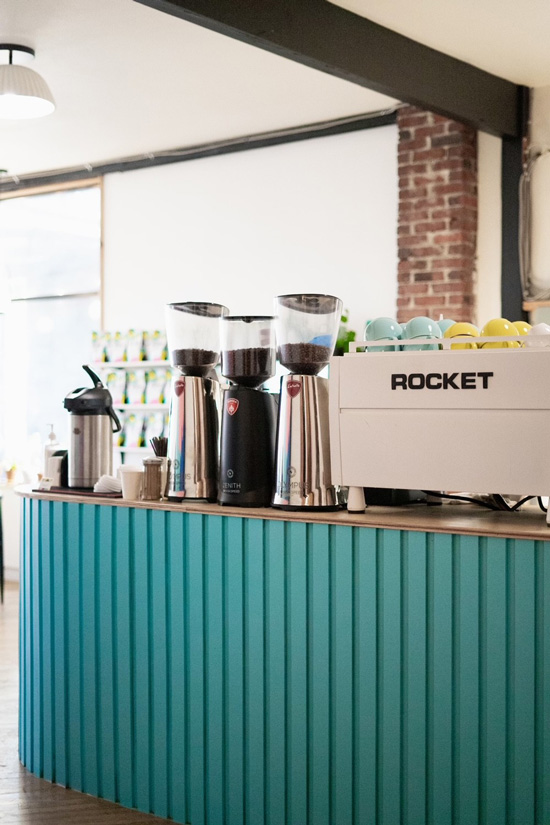 Rocket espresso machine sits atop counter at coffee shop next to ginders
