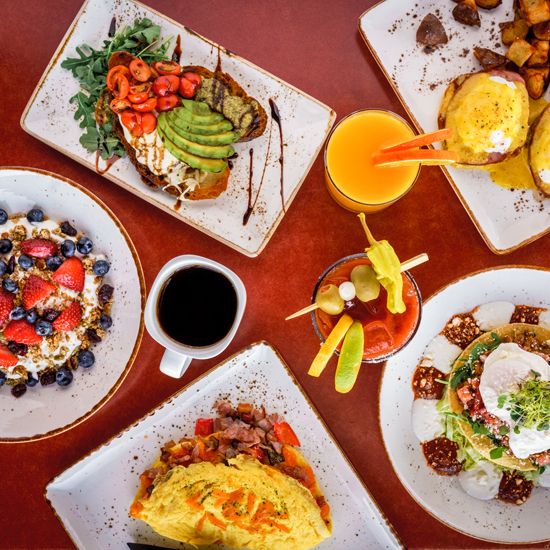 multiple breakfast entrees, a cup of coffee, bloody mary and orange juice from above