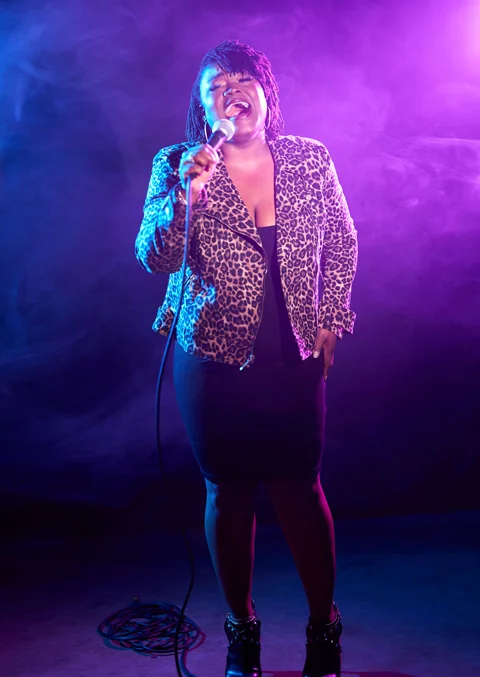 Woman sings into microphone.