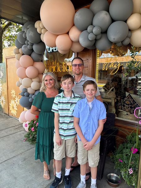 family of four stands in front of storefront