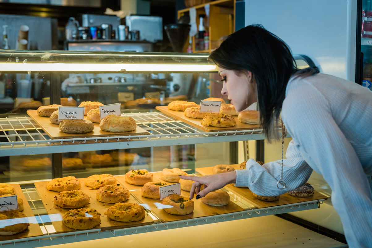 woman points to pastry in a display case