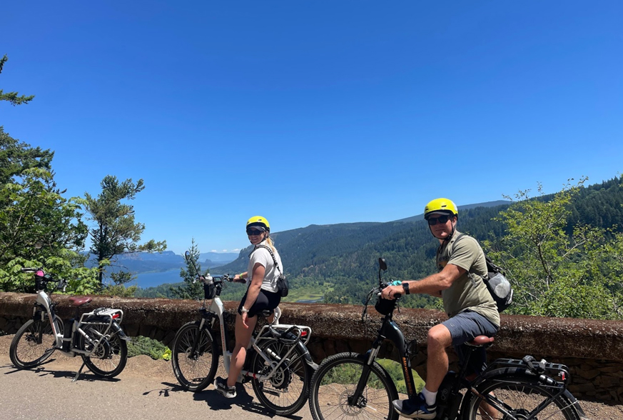 two people on bikes with view of Columbia River Gorge
