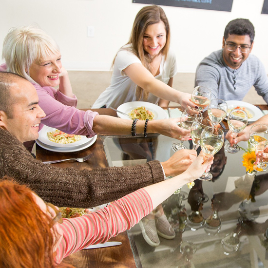 group cheers wine glasses seated at a table