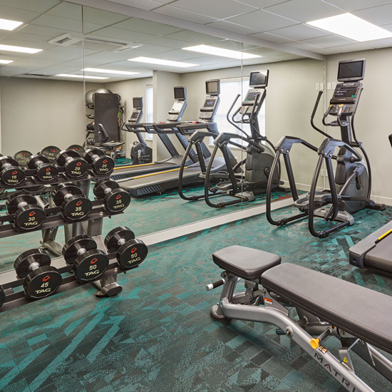 hotel fitness center with free weights, elliptical machines and treadmills