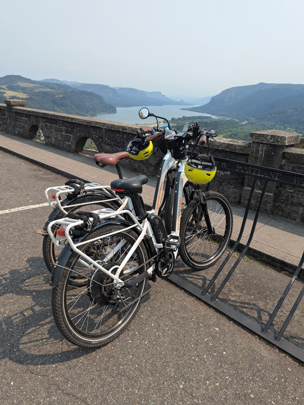 two ebikes parked in bike rack with view of Columbia River Gorge