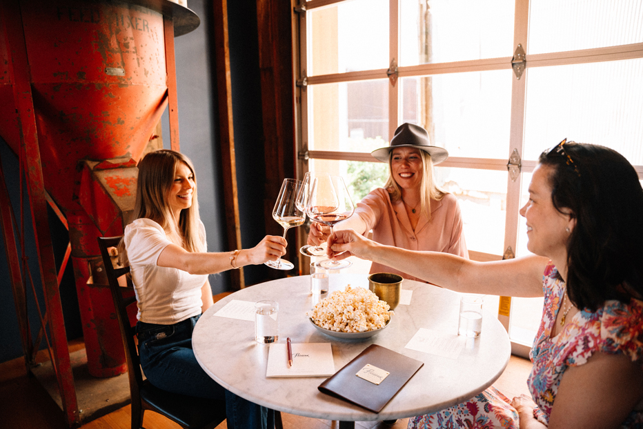 a party of three cheers their wine glasses