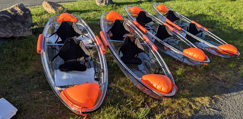 four 2-person kayaks in a row on grass