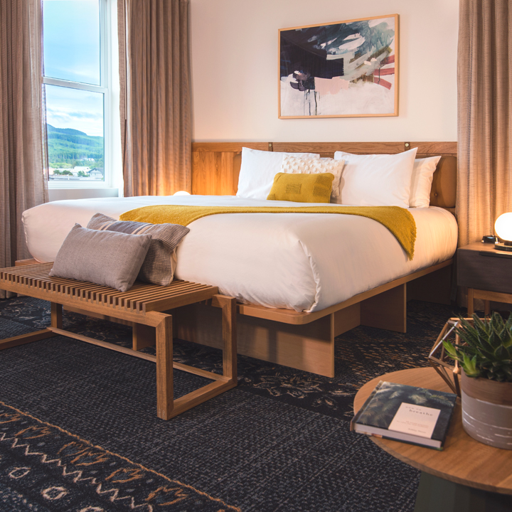 interior of hotel room with queen bed and view out the window