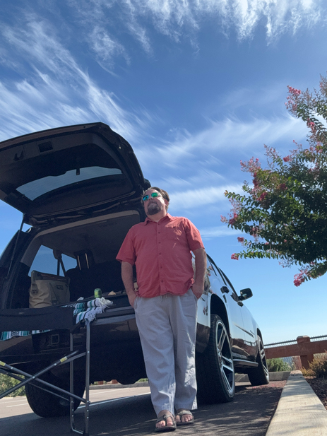 Mark Patterson of May Your Glass Be Filled wine Tours stands at the back of his touring van