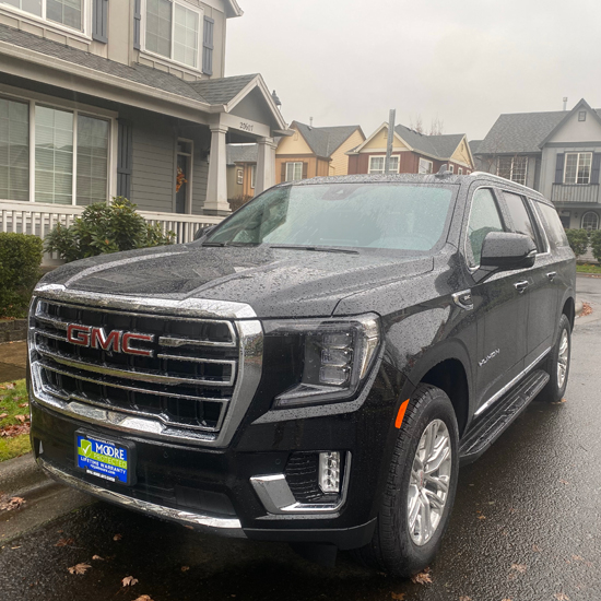 GMC SUV parked in front of two story house