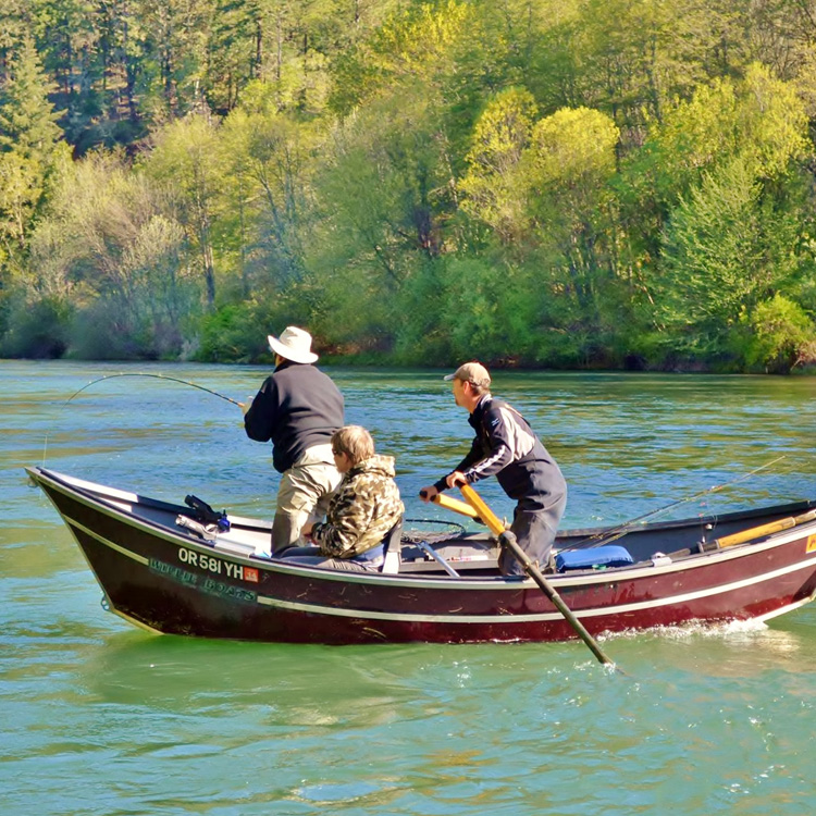 three people on body of water in boat. one is seated. one is fishing. one is rowing.