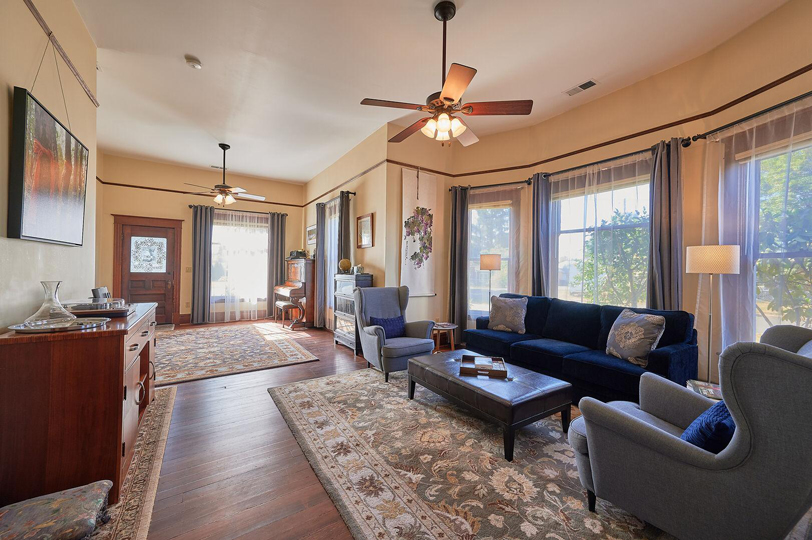 Spacious living room with hardwood floors, a large area rugs, and multiple seating options.