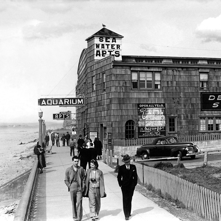 historic photo of people walking on ocean beach promenade