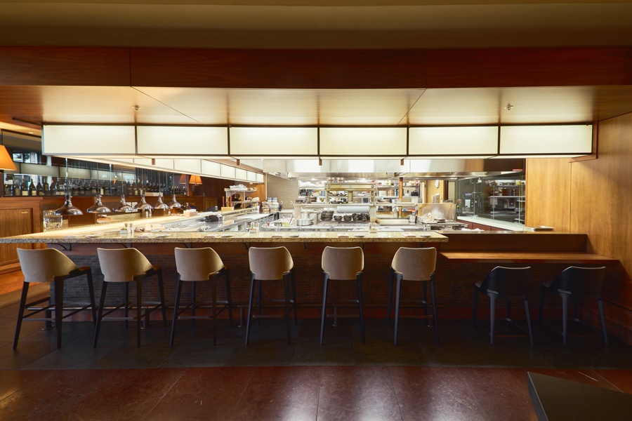 long bar with view of restaurant kitchen