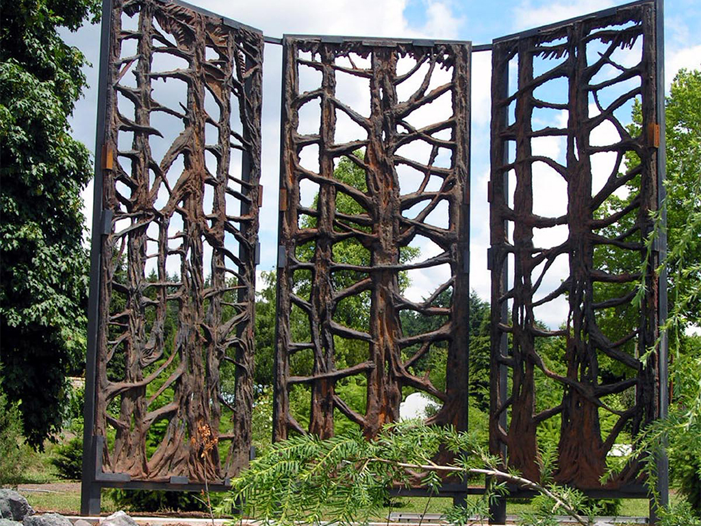 three large panels of wooden art displayed outdoors