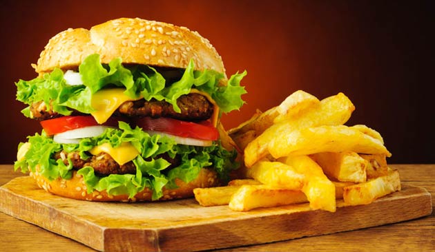 Hamburger with fries on a wooden board.