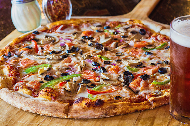 A delicious veggie pizza with glass of beer
