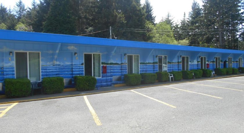 exterior of blue motel with ocean mural painted on it