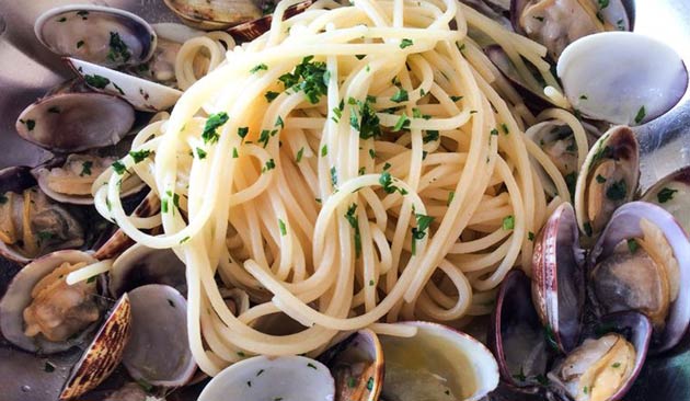 Spaghetti with clams and parsley in a bowl.
