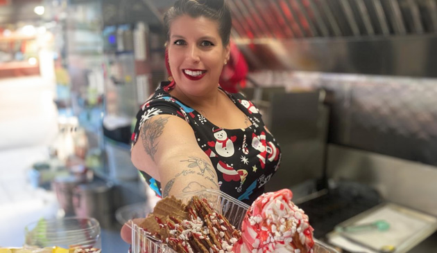 Food truck owner holding out basket of waffles and ice cream