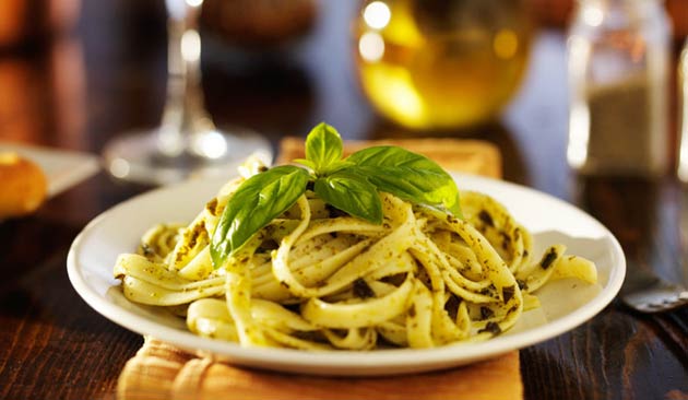 Plate of pasta with basil leaves.