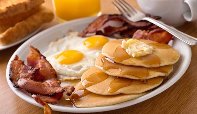Plate of eggs, pancakes, bacon, and toast.