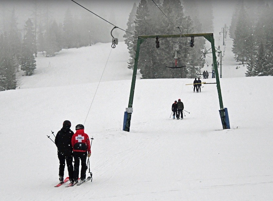 Skiers riding up the surface lift.
