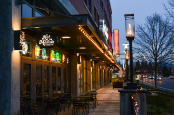 storefronts with signs lit up in the evening