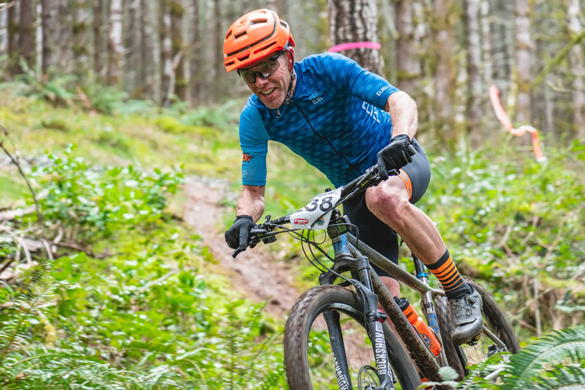 A man bikes through a lush mountain trail