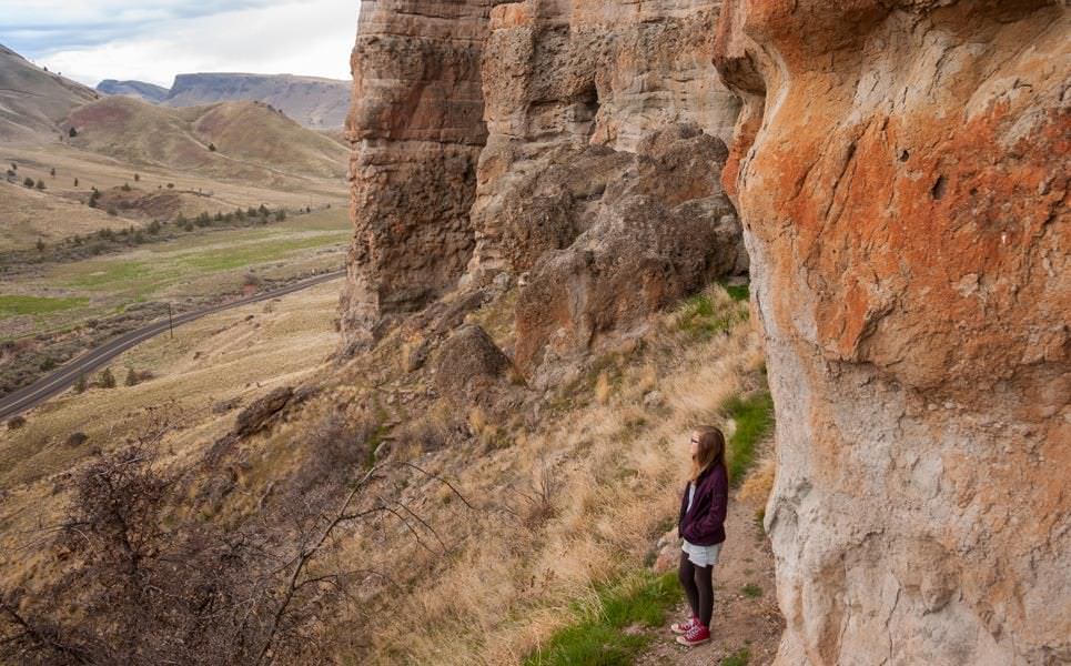 A woman standing and enjoying the view of the rock formations at the Clarno Unit.