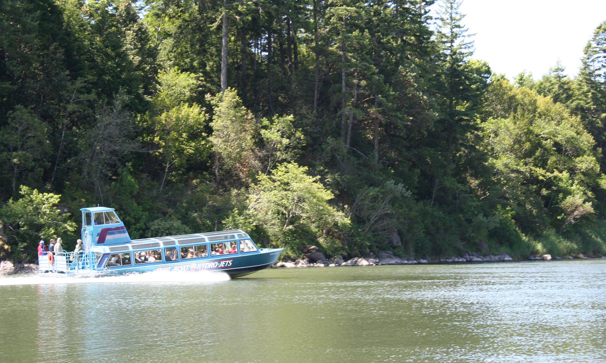 People touring the Rogue River on a jet boat