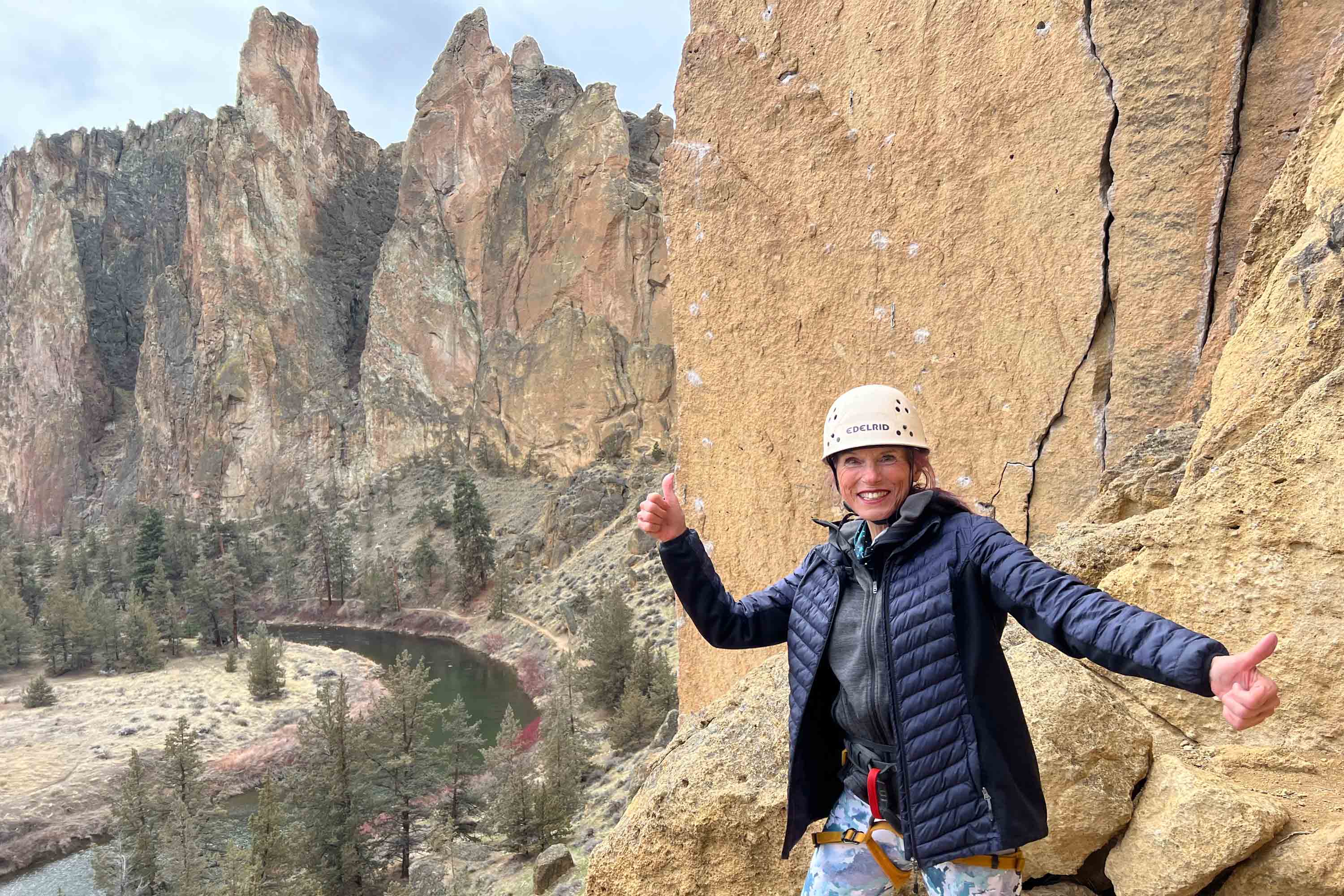 A woman flashes a thumbs up after climbing Smith Rock