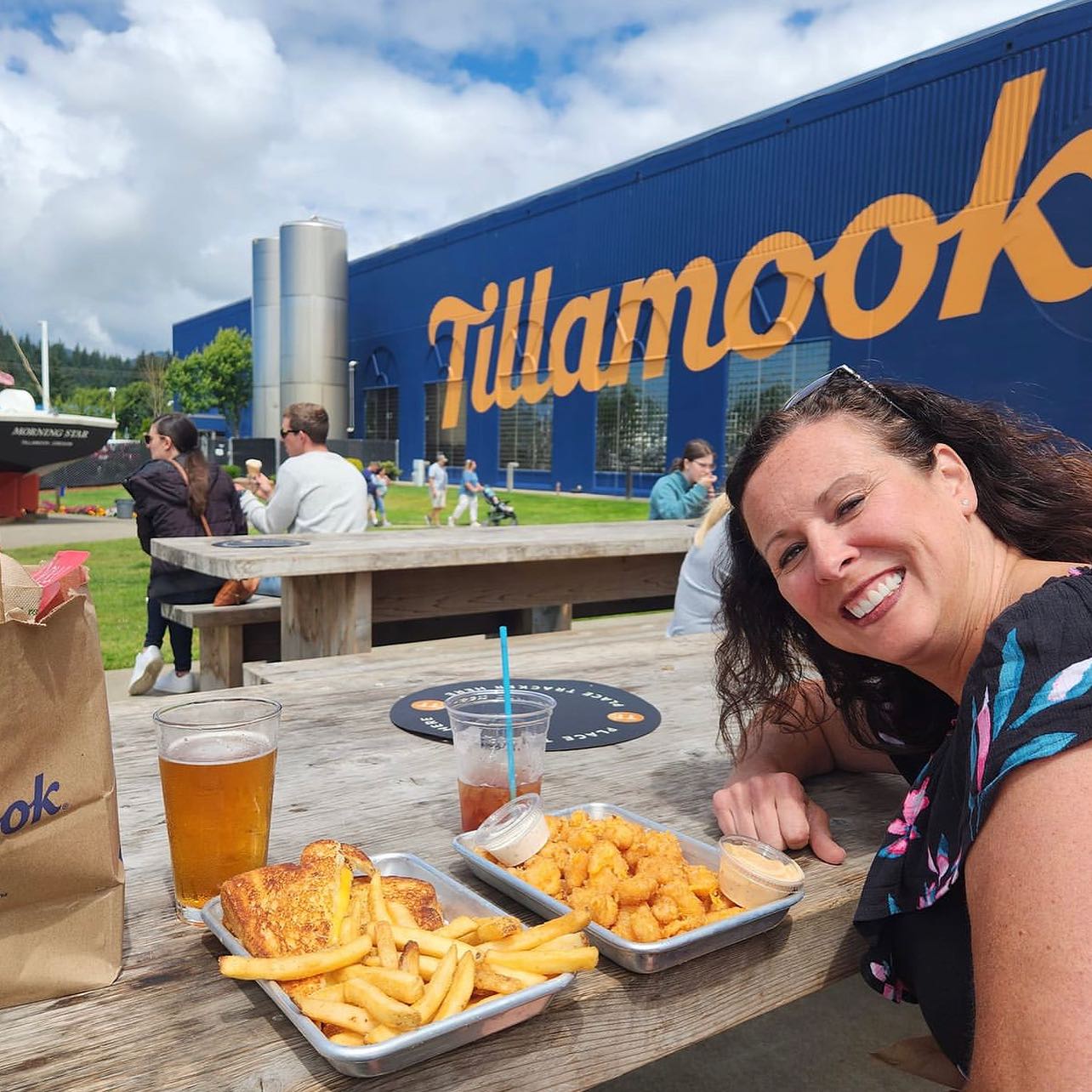 A woman smiling at a platter of Tillamook Cheese products.