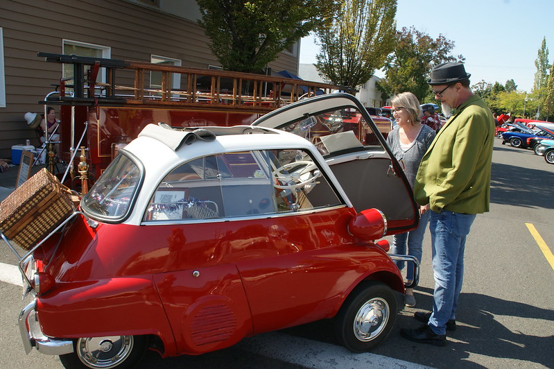 Two people looking at tiny classic car