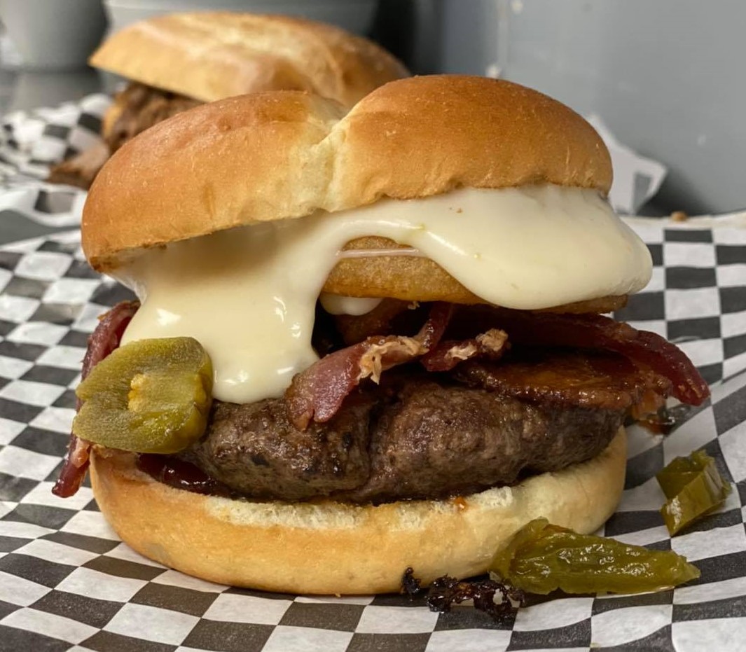 Photo of burger with melting cheese and peppers