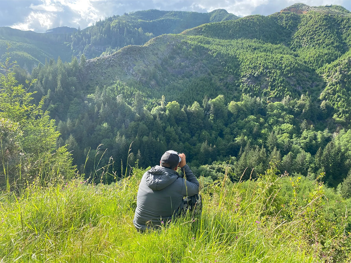 Man with binoculars in the forest in Oregon