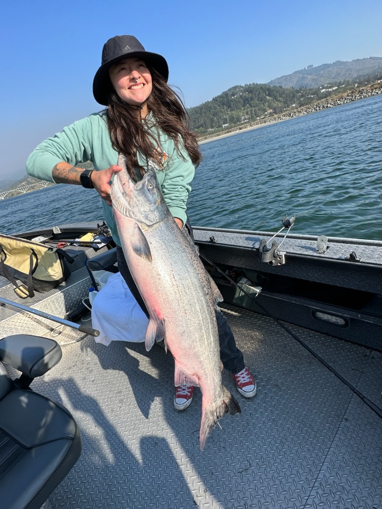 Woman holding a large fish, caught in the ocean near Gold Beach, Oregon