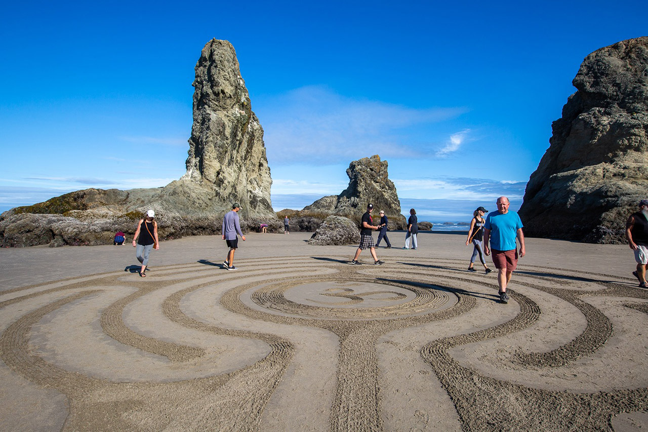 People walking the sand art labrynth by Circles in the Sand in Bandon, Oregon