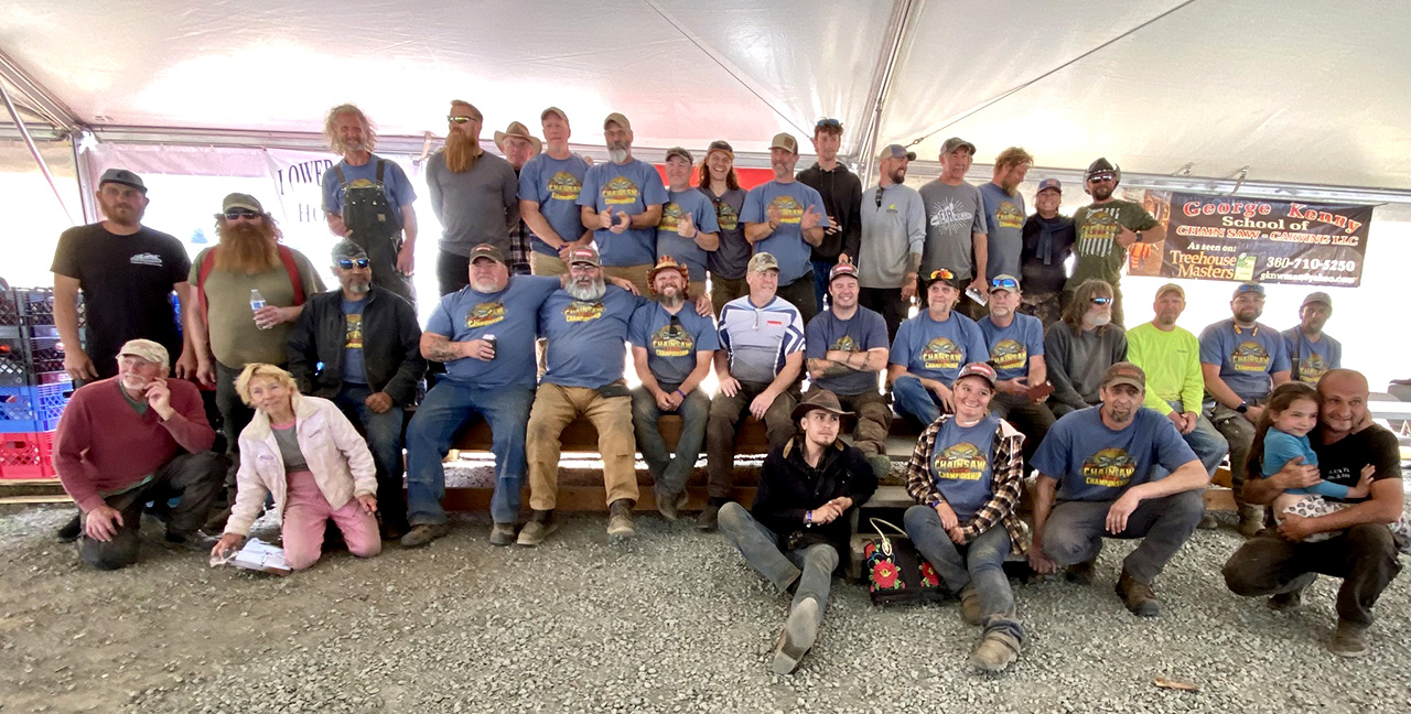 Group photo of chainsaw carvers at the Oregon Divisional Chainsaw Carving Championship in Reedsport, Oregon