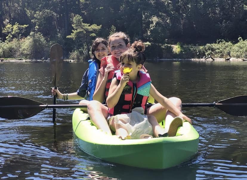 Girls kayaking on the lake with rentals from Coastal Kayak & SUP Rentals in Coos Bay, Oregon