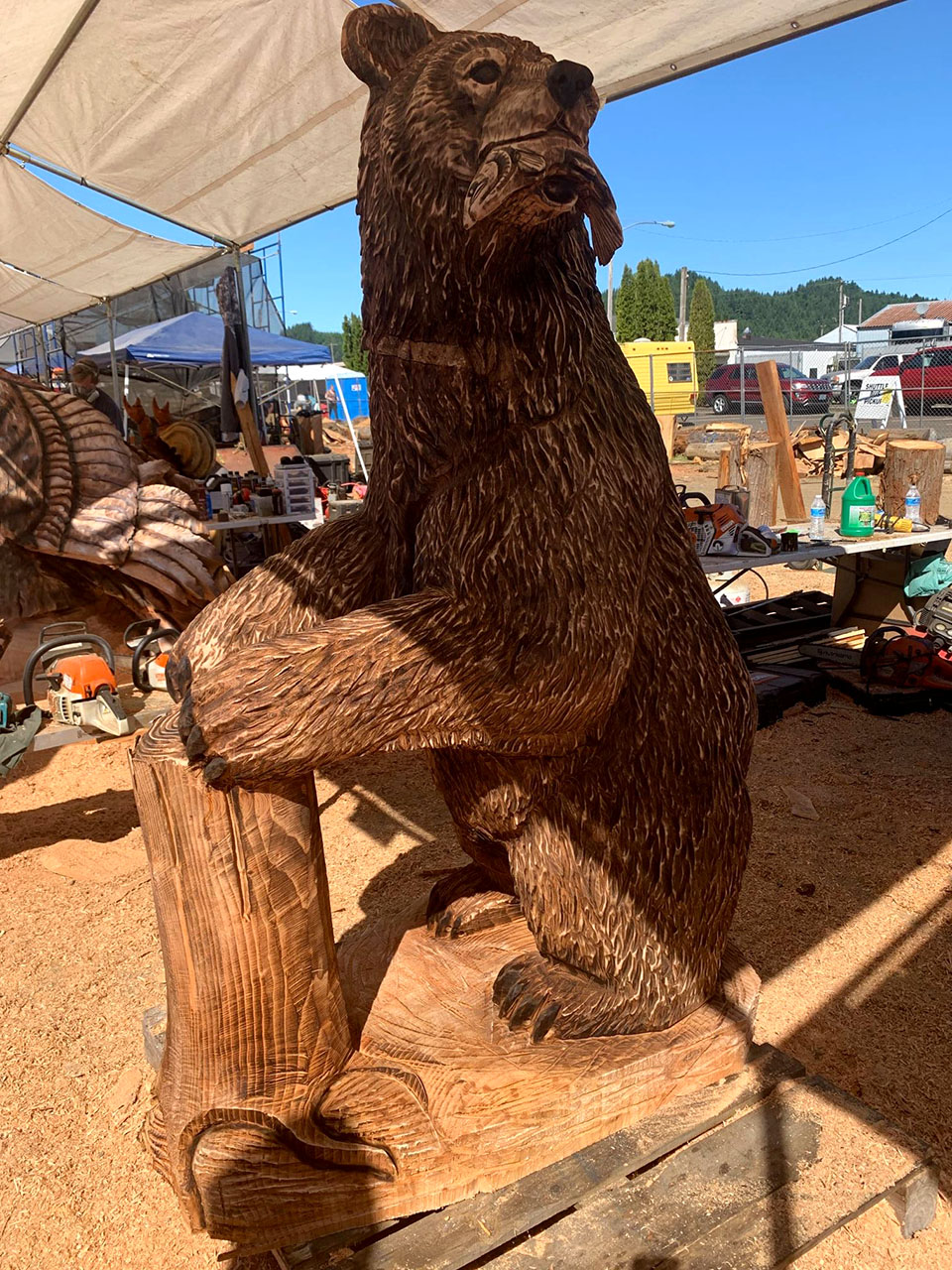 Chainsaw carving of bear with salmon at the Oregon Divisional Chainsaw Carving Championship in Reedsport, Oregon
