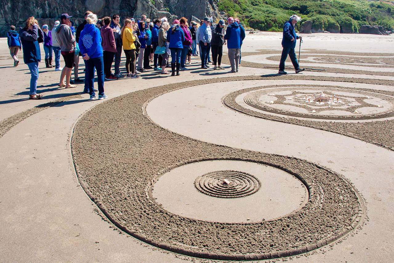 Crowd of people watching sand art by Circles in the Sand in Bandon, Oregon