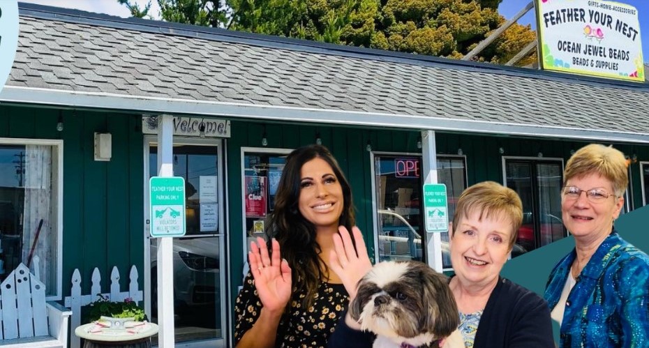three people, one holding small dog, small at camera while standing in front of one story retail store